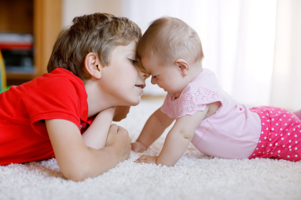 快乐的小男孩和刚出生的女婴，可爱的妹妹。兄弟姐妹。弟弟和宝宝在一起玩图片下载