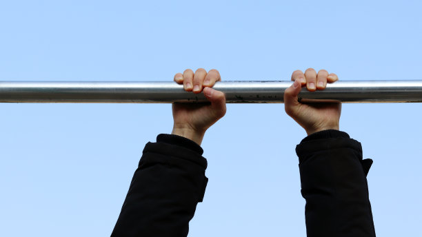 冬季需要少量的运动。双手挂在引体向上的杠子上图片下载