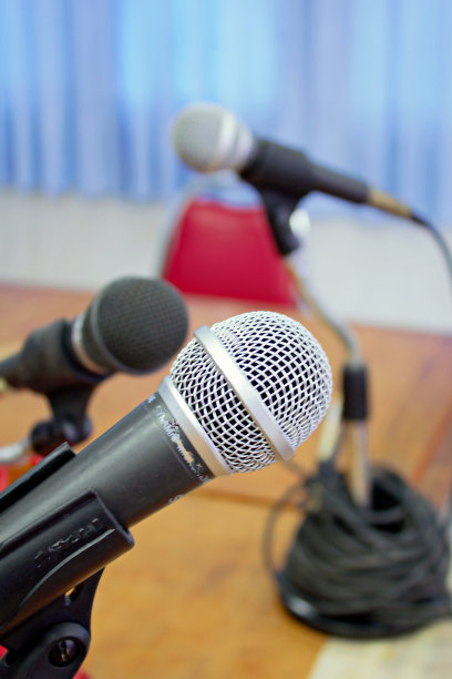 麦克风架上的三个麦克风会议室的红色会议椅图片下载