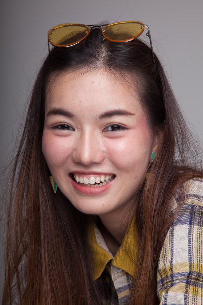 戴着黄色太阳镜的漂亮年轻亚洲女人图片下载