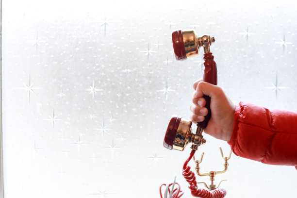 复古红色手机的女人的手。图片下载