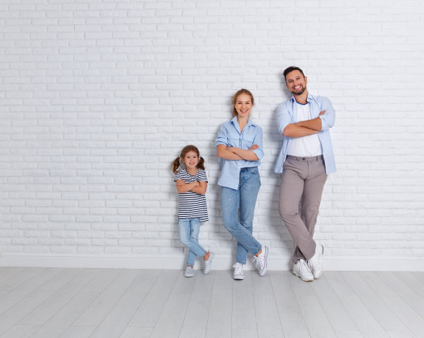 幸福的家庭母亲父亲和孩子靠近一堵空砖墙图片下载
