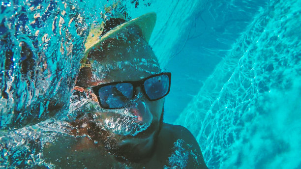 一个男人带着充气床垫掉进了游泳池图片下载