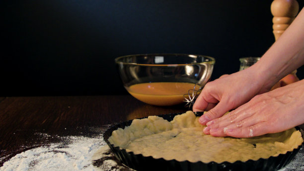 女性手在烤盘上涂面团图片下载