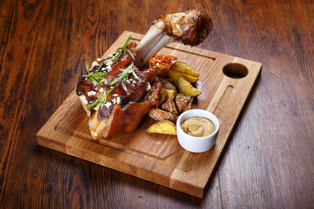 桌上放着煮好的小腿肉、土豆、酸菜、芥末图片下载