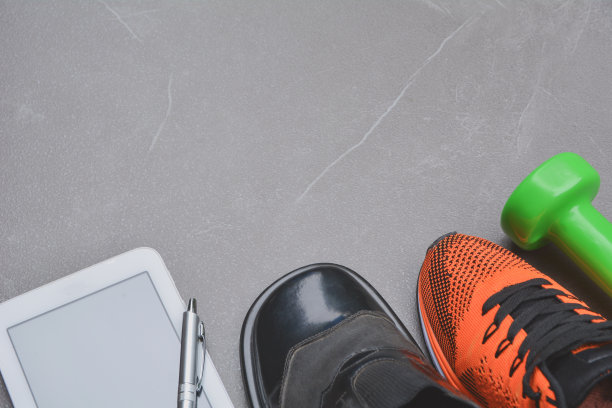 生活平衡概念为工作和运动在俯视图一半的商业和运动鞋。图片下载