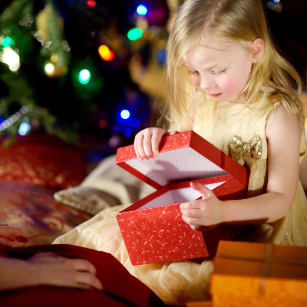 快乐的小女孩从她的父母那里得到了圣诞礼物图片下载
