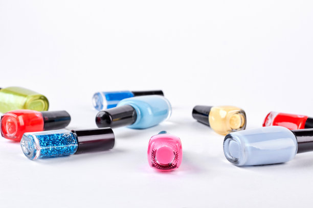 指甲油瓶子躺在白色的背景上。图片下载