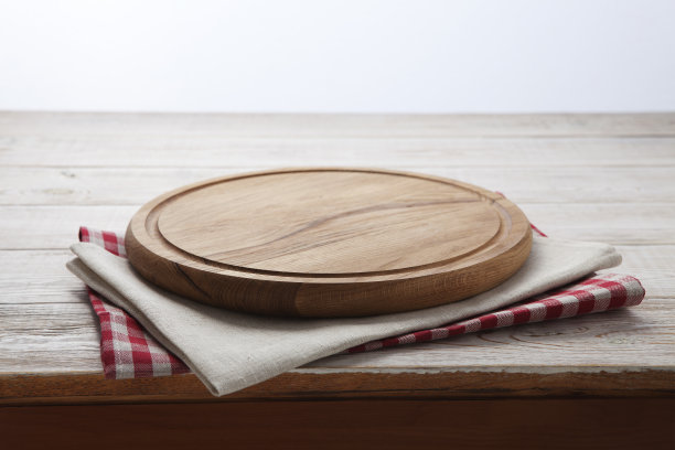 餐巾。堆叠的彩色盘子毛巾在白色木制桌子的背景俯视图素材图片