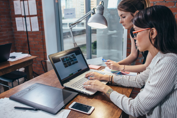 女室内设计师工作与客户使用笔记本电脑看图片坐在现代工作室图片下载