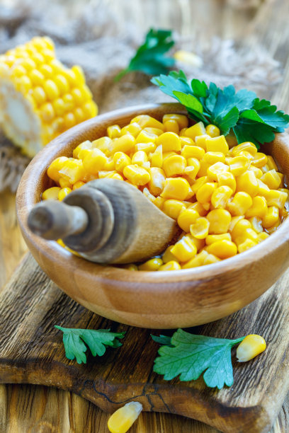 碗里装着甜玉米和木勺。图片下载