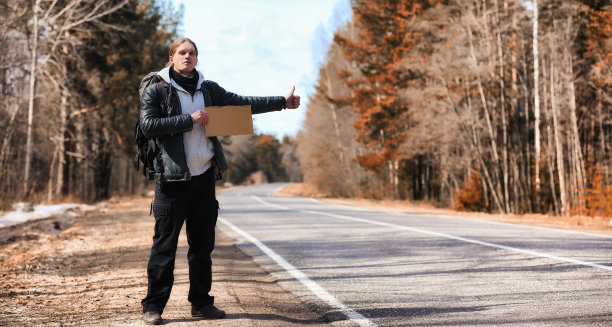 一个年轻人正在搭顺风车周游全国。这个人正在尝试图片下载