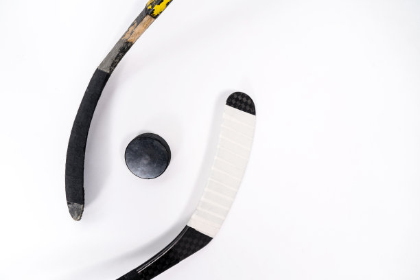 冰球和曲棍球棒在孤立的白色背景，复制空间。图片下载