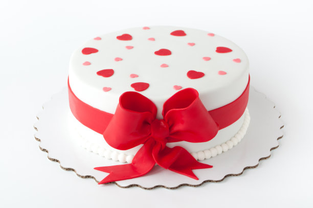 艺术蛋糕用红丝带、蝴蝶结、心形装饰。素材图片