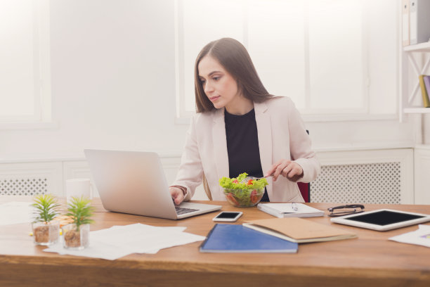 年轻的女商人在办公室吃沙拉图片下载
