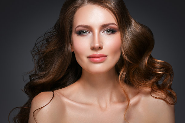 美丽的头发女人美丽的皮肤肖像在黑暗的背景。长美丽健康的头发模特女孩库存形象。图片下载