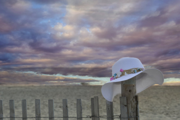 篱笆上的帽子女人，多云的日落，Cape May，新泽西州，美国图片下载