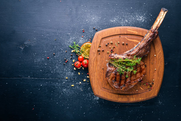 牛排带骨。前视图。文本的空闲空间。在木制的背景上。图片下载