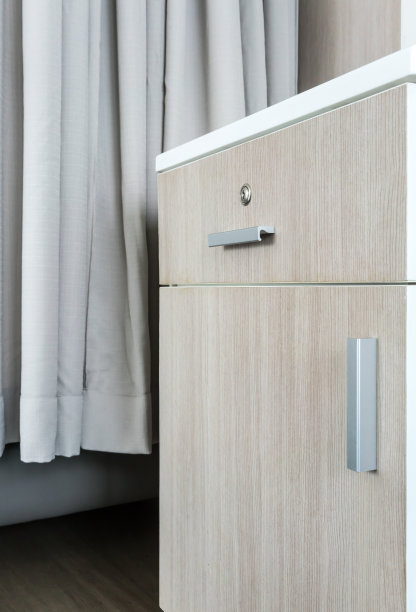 无尘室里的银色金属手柄、白色纤维顶、米色窗帘的小木柜。图片下载