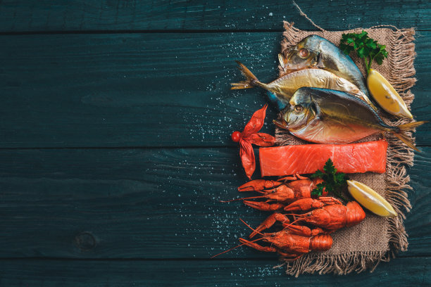 海鲜。呕吐鱼、龙虾、鲑鱼。在木制的背景上。前视图。文本的空闲空间。图片下载
