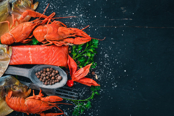 海鲜。呕吐鱼、龙虾、鲑鱼。在木制的背景上。前视图。文本的空闲空间。图片下载
