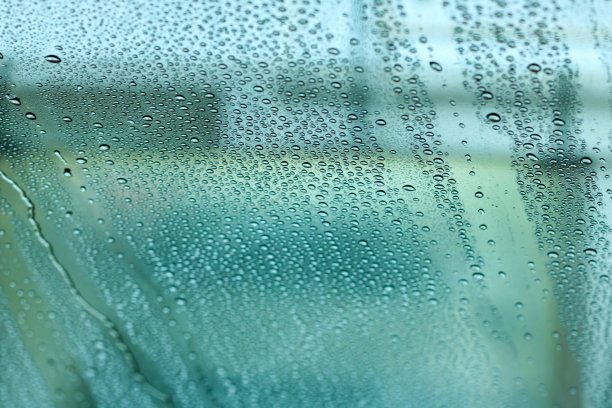 玻璃上模糊的雨滴。图片下载
