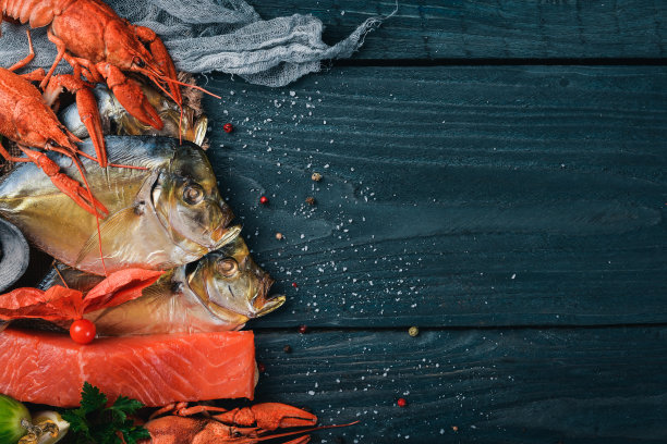 海鲜。呕吐鱼、龙虾、鲑鱼。在木制的背景上。前视图。文本的空闲空间。图片下载