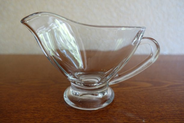 玻璃碟船从侧面放在木桌上图片下载