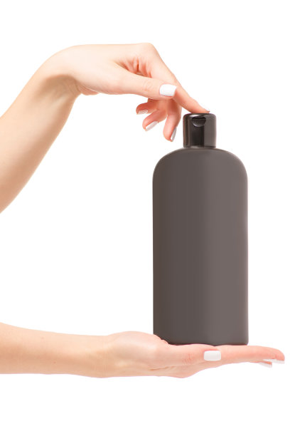 一个女人手里拿着一瓶洗发香波图片下载