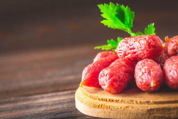 木桌上放着小熏香肠。图片下载