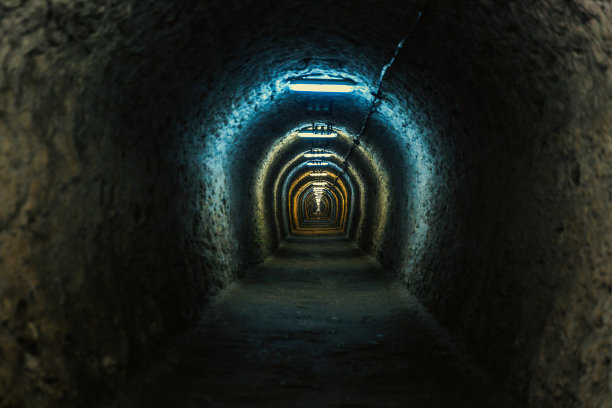 照明的地下拱形隧道与粗糙的墙壁图片下载