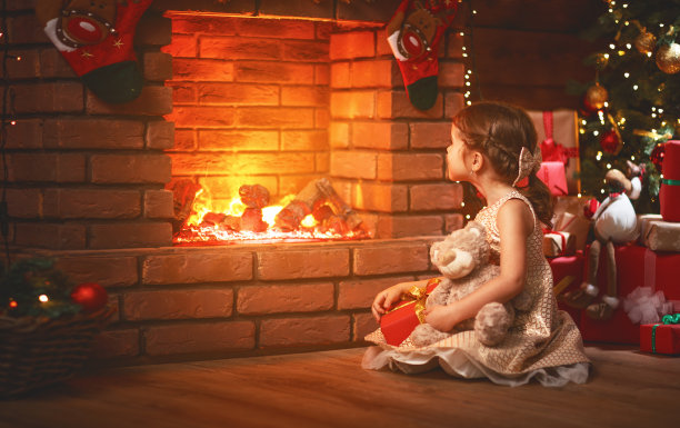 快乐的小女孩带着圣诞礼物在家图片下载