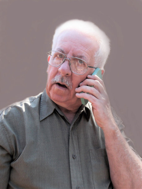 年长的白发男子接受手机电话或听他的语音邮件信息图片下载