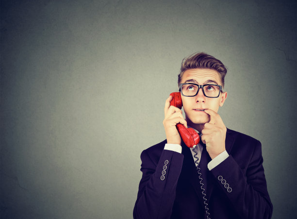 误解和远距离通话。心烦意乱，担心，困惑的人在电话上有许多问题孤立的灰色背景。素材图片