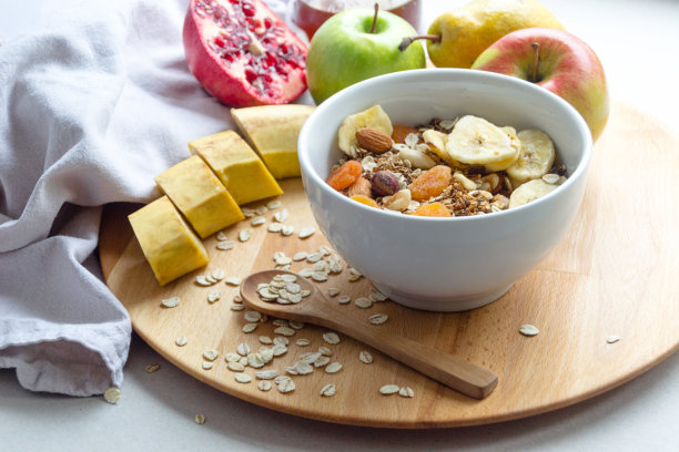 盛有谷物和水果的碗，置于圆形托盘上的照片图片下载