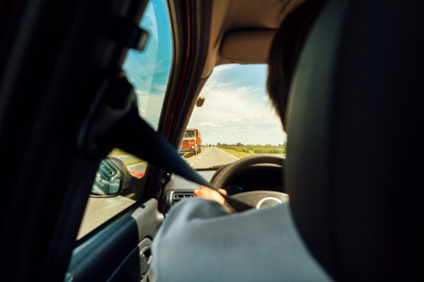 从后面看到的一个人开着一辆汽车在路上，前面有一辆卡车图片下载