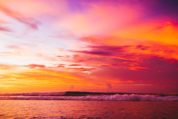 在日落或日出时，冲浪彩色海浪落下素材图片