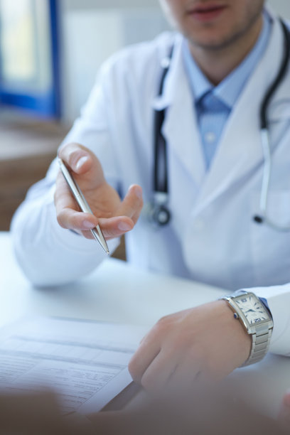 医生在办公室和女病人谈话。医生和病人在讨论什么，只是手放在桌子上。医疗保健和医疗理念。图片下载