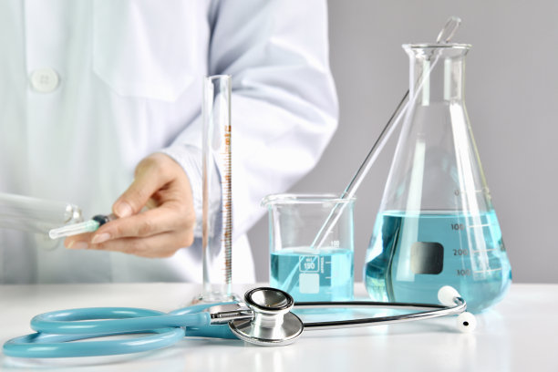 医生拿着装有药用疫苗的注射器，实验室玻璃器皿，药物研发概念。（选择性聚焦）图片下载