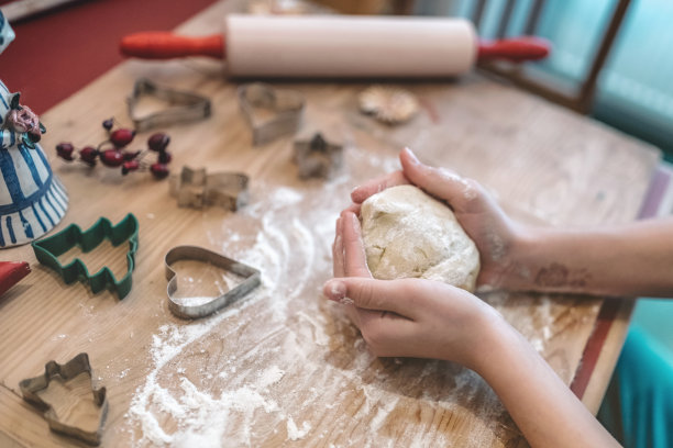 女人的手在木头桌上揉圣诞饼干面团图片下载