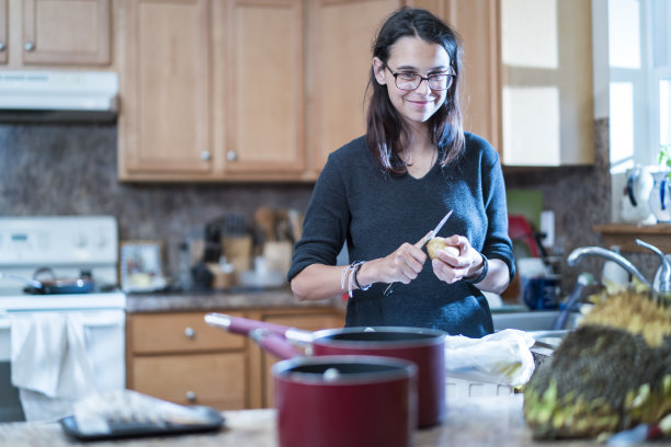 在宾夕法尼亚州波科诺的奥尔布莱特斯维尔，一个女孩在家里的厨房里准备食物图片下载