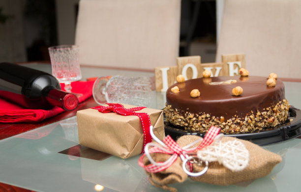 桌上放着礼物和酒的生日蛋糕图片下载