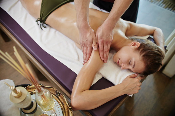 男按摩师在水疗中心按摩年轻女子图片下载