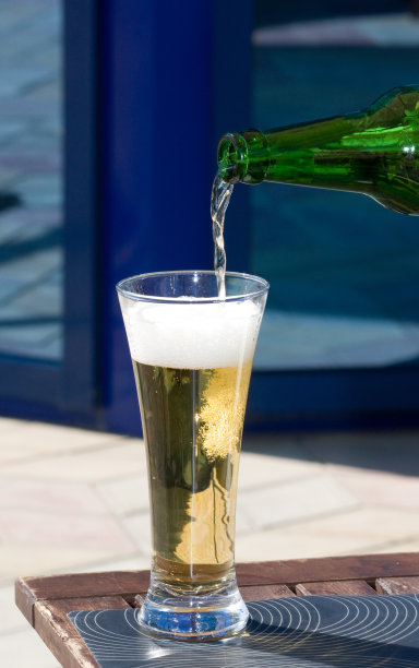 啤酒从瓶中倒入高脚杯图片下载