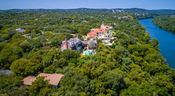 位于绿山之上的大豪宅，以河流为背景图片下载