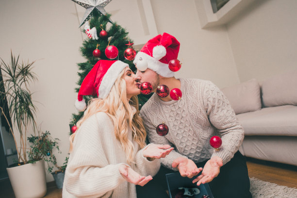 当圣诞装饰品挂在空中时，情侣接吻图片下载