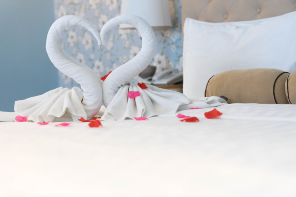 在房间的白色干净床上用毛巾作鸟装饰图片下载