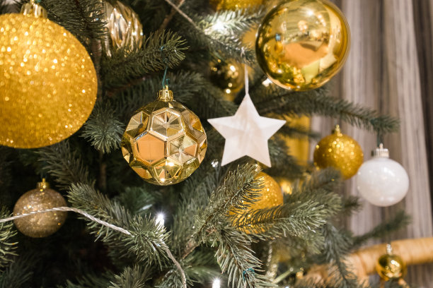 用星星和金球装饰圣诞树，在冬天用模糊的雪散景背景图片下载