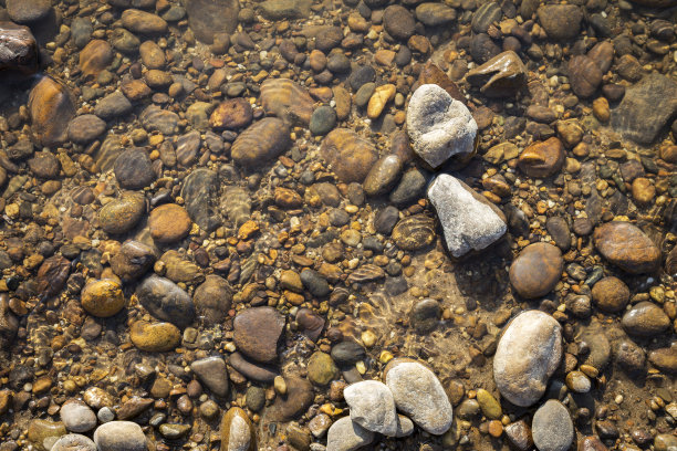 清澈的河水，以天然石材为背景图片下载