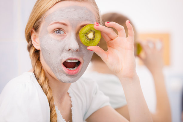 快乐的年轻女子戴着面具拿着几维鸟图片下载